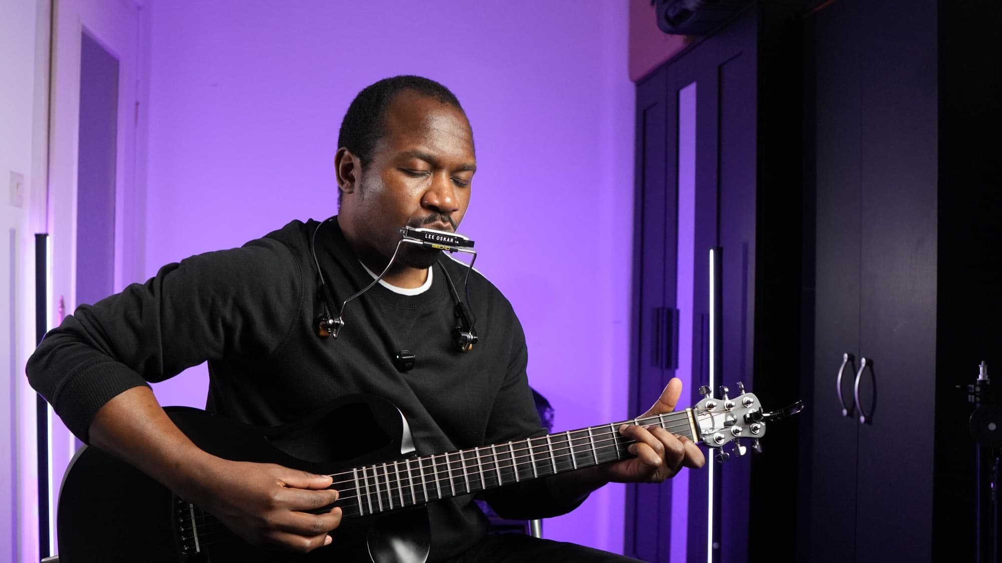 Playing harmonica on a neck rack and guitar at the same time
